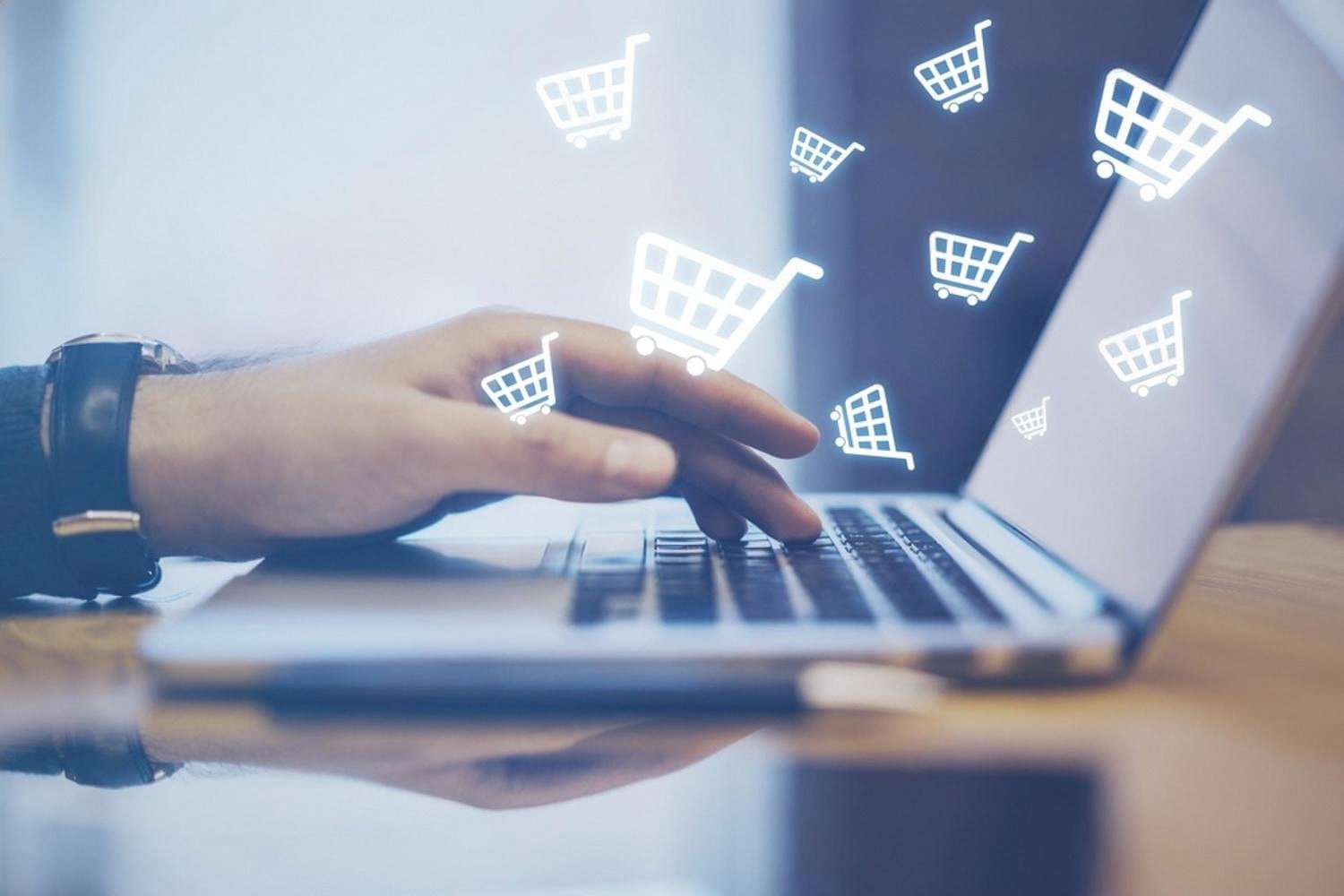 Hand typing on laptop with shopping cart icons representing online rental listings in the UAE